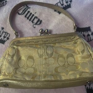 Woman’s gold coach clutch bag